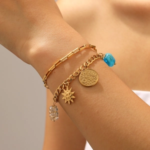 Close-up of golden layered bracelet with sun and celestial coin pendants with beads