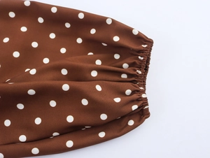 Detailansicht der elastischen Manschetten an einem braunen Vintage-Punktkleid mit Naht