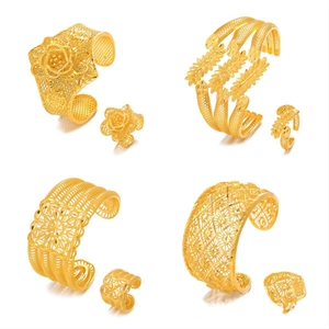 Gold hollow cuff bracelet and ring jewelry set featuring intricate rose and leaf carving