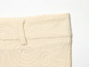 Détail macro de broderie crème sur la ceinture en tissu coton-lin de haute qualité