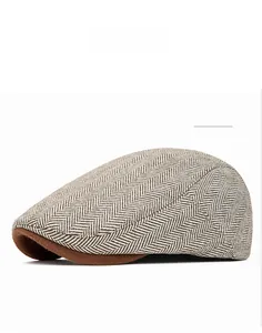Close-up of khaki herringbone tweed fabric and brim detail on a vintage flat cap