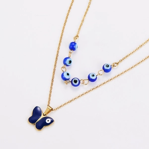 Close-up of golden layered necklace with blue devil eye beads and butterfly pendant
