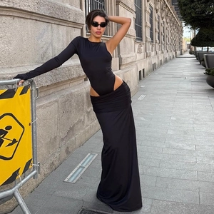 Women's black two-piece set with a one-shoulder crop top and matching floor-length skirt