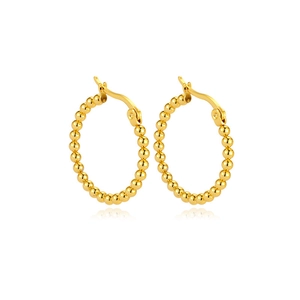 Detailed close-up of golden beaded hoop earrings with a high-polished metallic finish