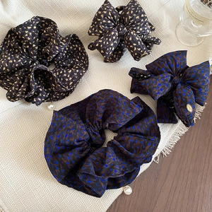 Detail of polka dot bow hair clip and scrunchie set with love charm and pearl accents