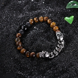Skull bracelet with tiger eye stones and black beads on a dark textured background