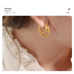 Close-up of 18K gold plated twisted rope and smooth C-shaped earrings on model