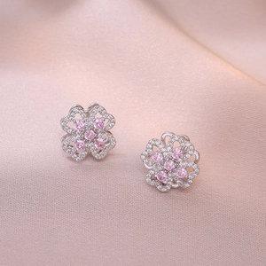 Macro shot of clover-shaped stud earrings with pink gemstone and white cubic zirconia