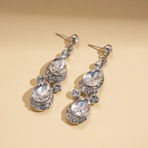 Close-up of silver teardrop earrings featuring sparkling clear crystals in a luxury style
