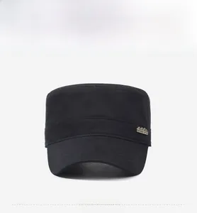 Detail of military cadet cap showing a vintage metal badge with outdoor style engraving