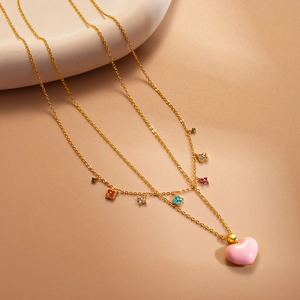 Golden necklace featuring pink enamel heart pendant and multi-colored floral charms