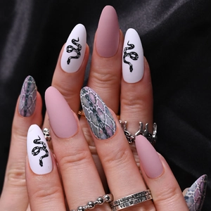 Detailed view of matte pink and black snake pattern almond press-on nails on silk