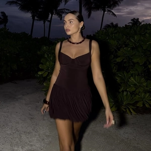 Photo de plage montrant les plis texturés et le tissu violet foncé de la mini robe