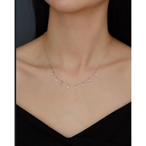 Detail of s925 silver necklace with diamond-shaped tassel pendants and zircon on a model