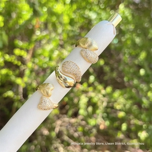 Macro detail of three 18K gold plated rings featuring heart and teardrop pave zircon accents