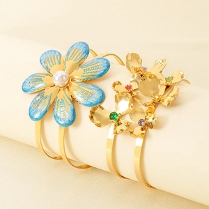Detail of flower bangles with colorful gemstones, pearls, and gold-plated metal texture