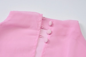 Detail of pink chiffon dress neckline with three matching fabric-covered buttons and loops