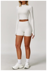 Front view of white long-sleeve zipper top and high-waisted seamless fitness shorts set
