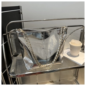 Silver metallic tote bag on a display stand with a gold and silver chain strap