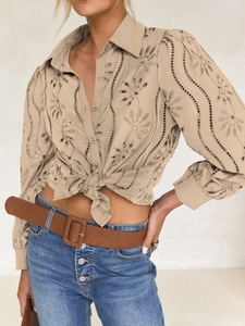 Detailed view of beige lace embroidery and hollow out puff sleeves with button closure