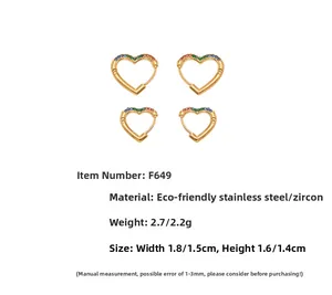 Detail view of heart-shaped gold earrings with colorful zircon inlay in two sizes