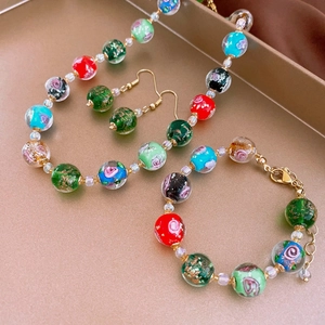 Flat lay of colorful glass bead jewelry set including necklace, bracelet and earrings
