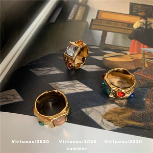 Vintage wide gold ring with hammered texture and colorful gemstones in retro style