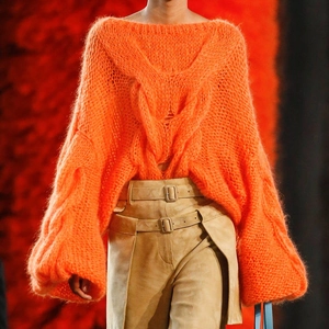 Detail of orange chunky knit mohair sweater paired with khaki suede belted trousers
