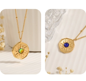 Close-up of vintage gold sunburst coin necklaces with colorful gemstones on a bead chain