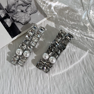 Classic pearl and crystal hair clips in silver and charcoal gray with natural light shadow