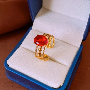Detail of vintage gold ring with red oval stone in a blue jewelry gift box