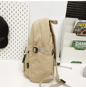 Vista lateral de la mochila oxford beige con hebillas ajustables y detalle de bolsillo lateral