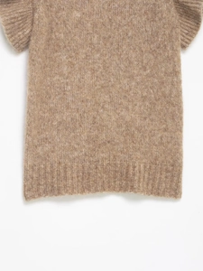 Close-up of oatmeal knit sweater vest showing ribbed hem and fuzzy wool texture