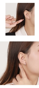 Close-up of S925 sterling silver huggie earrings with cubic zirconia on female model