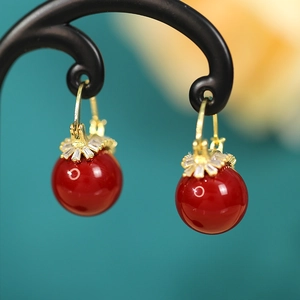 Macro detail of red pearl drop earrings with sparkling zircon gemstones and gold finish