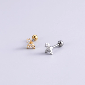 Détails macro des clous d'oreilles feuille or et argent avec zircons et fermoir boule