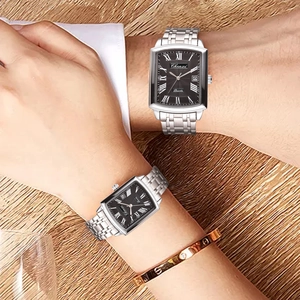 Close-up of couple wearing silver square steel watches with black dials on wrist
