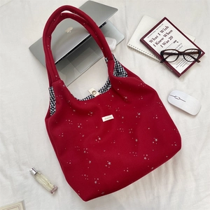 Détail du sac cabas rouge à étoiles montrant la doublure à carreaux noirs et blancs