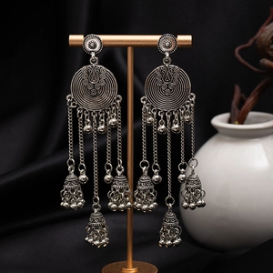 Detail view of vintage silver tassel earrings with floral discs and hanging bells