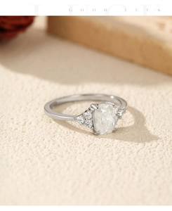 Macro detail of 1 carat moissanite ring with cushion cut center stone on textured surface