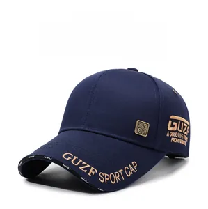 Détail de la broderie dorée et du logo métallique sur la casquette en coton bleu marine