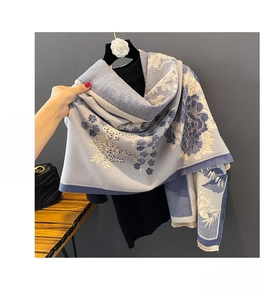 Detail of soft blue jacquard scarf showing double-sided winter floral pattern on model
