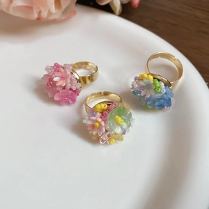 Dettaglio di tre anelli floreali fatti a mano su un vassoio di ceramica bianca con oro