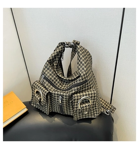 Macro shot of houndstooth weave texture and metal rings on a multifunctional tote bag