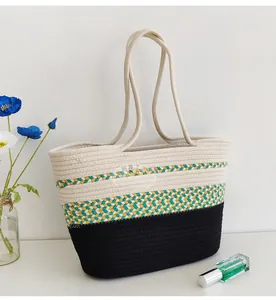Detail of handwoven color-block cotton rope tote bag with ethnic pattern and black base