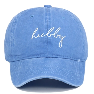 Dettaglio del ricamo bianco HUBBY su cappello da baseball in cotone lavato blu