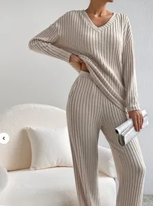 Detail of beige knit two-piece set featuring V-neck top and wide-leg ribbed trousers