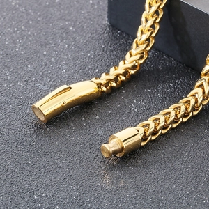 Detail of golden stainless steel wheat chain showing secure mechanical clasp closure