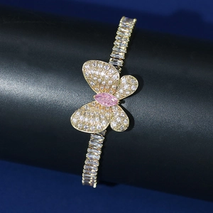 Macro shot of gold butterfly bracelet featuring pink marquise stone and zircon pavé