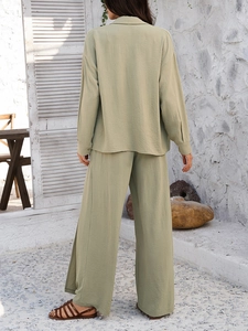 Back view of green casual set featuring long-sleeve shirt and wide-leg pants in textured fabric